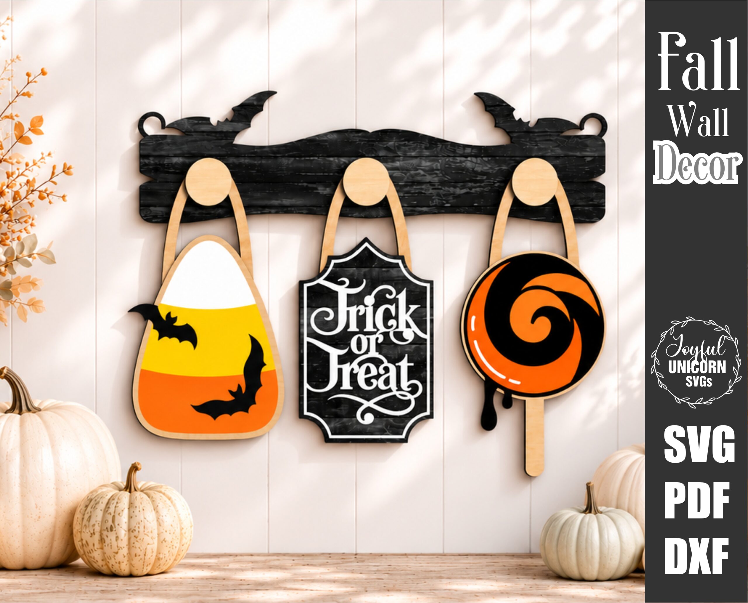 Interchangeable Halloween wall decor SVG Trick or Treat Sign, Candy Corn, and Halloween Lollipop hanging from wooden hooks on a decorative wooden display bar, laser cut file for Glowforge, CNC machines, and other lasers